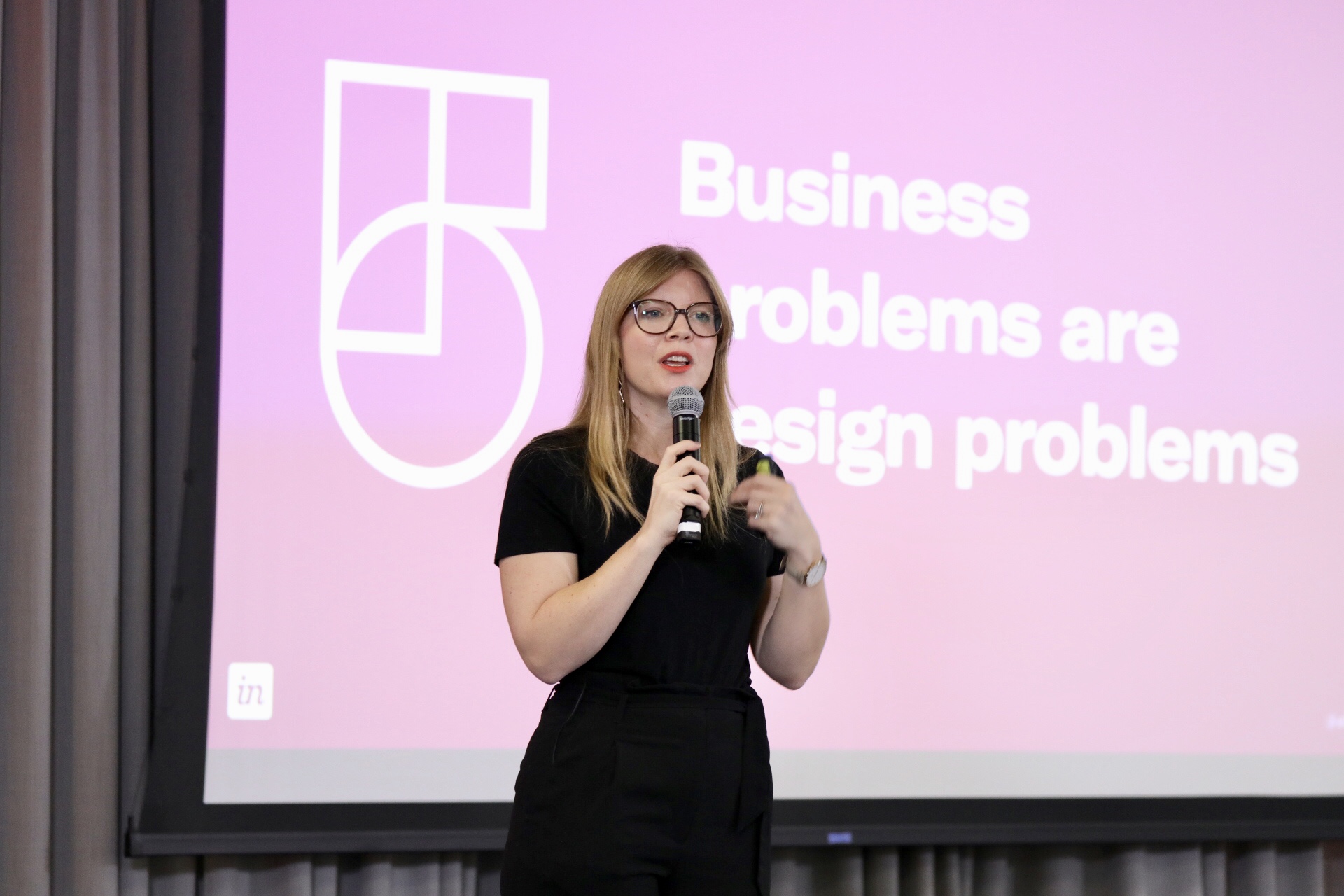 Me in front of a slide reading 'Business problems are design problems'