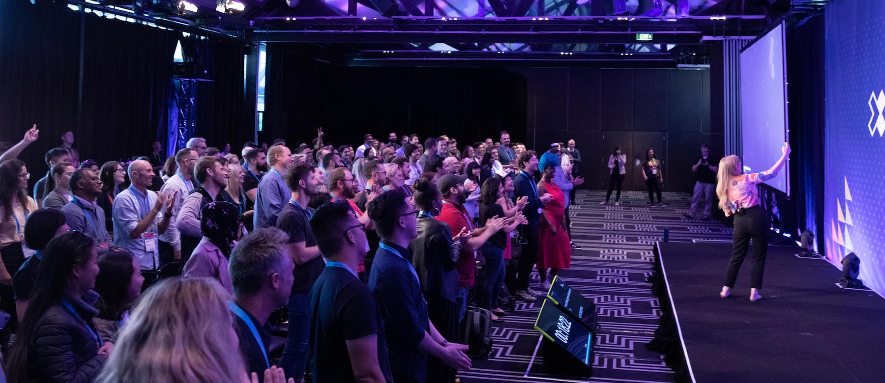 Emily on stage presenting to a crowd at a conference